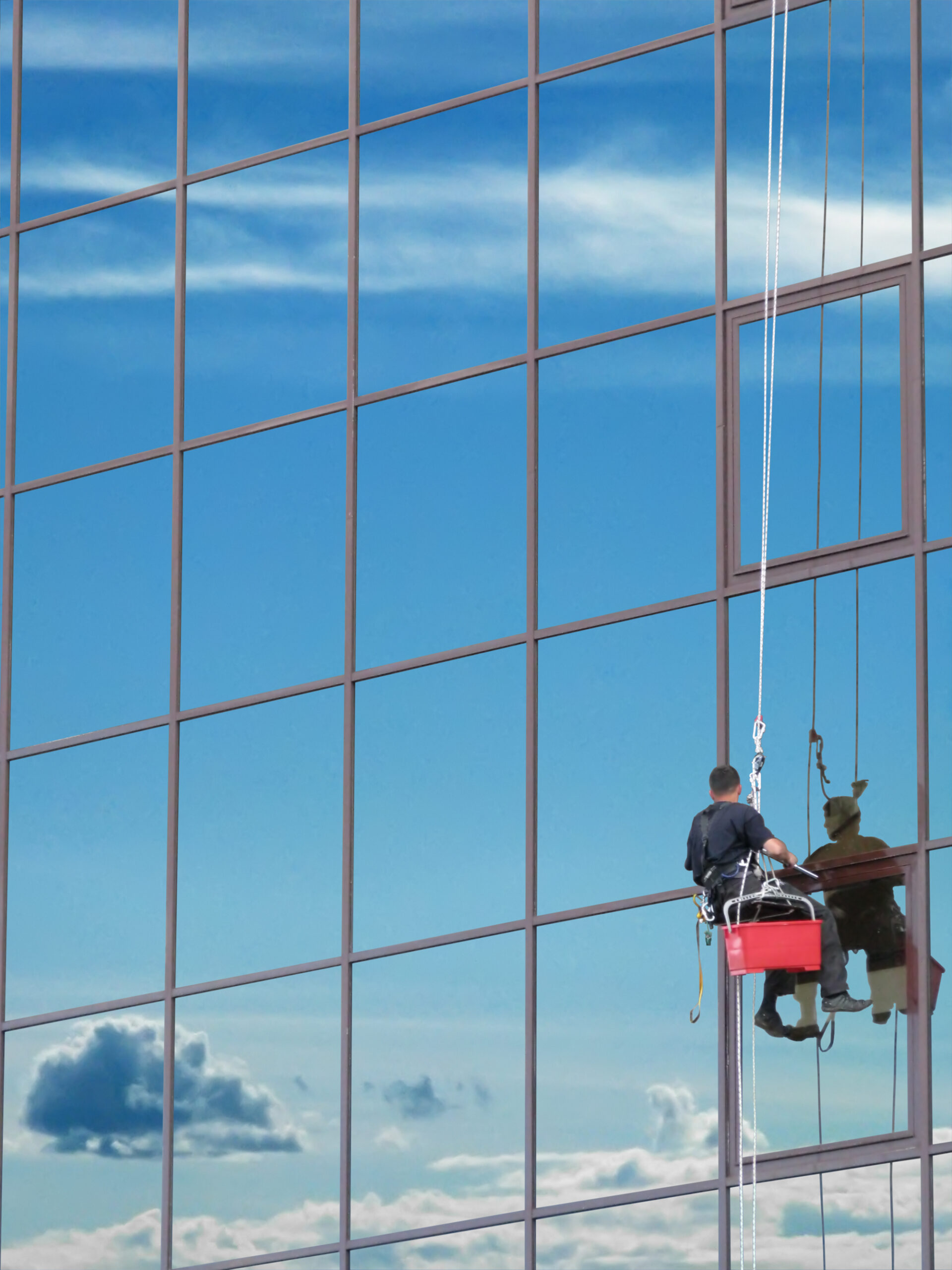 Window washer at work and reflect the sky in the windows